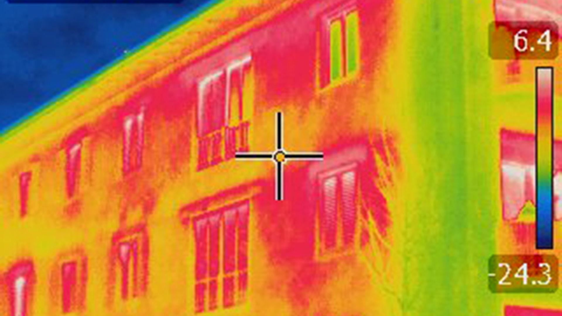 Thermal imaging of building showing heat loss through windows and walls