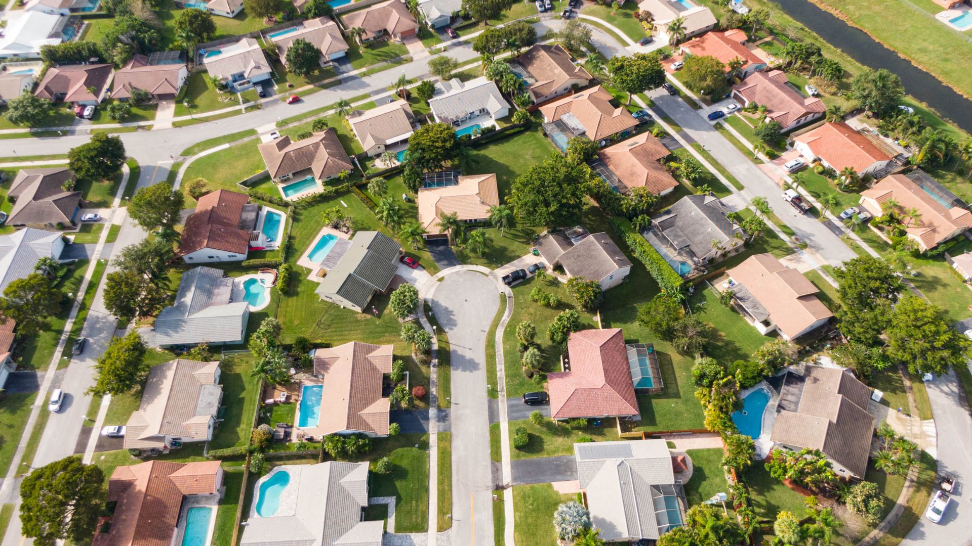 Aerial view of suburban neighborhood with houses and swimming pools